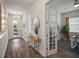 Hallway featuring hardwood flooring, modern lighting, an elegant mirror, and an open doorway at 7432 Paradiso Dr, Apollo Beach, FL 33572