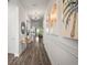 Light filled foyer with hardwood floors, stylish light fixtures, and decorative art accents on the wall at 7432 Paradiso Dr, Apollo Beach, FL 33572