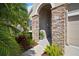 Close up of covered front entry featuring stone columns, lush landscaping, and a welcoming walkway at 7432 Paradiso Dr, Apollo Beach, FL 33572