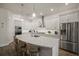 A pristine white kitchen features an island, white cabinets, stainless steel appliances, and stone countertops at 7432 Paradiso Dr, Apollo Beach, FL 33572