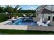 A modern pool design with in-pool seating, a neutral paver deck, and lush tropical landscaping at 7432 Paradiso Dr, Apollo Beach, FL 33572