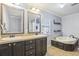 Bathroom featuring double sinks, a soaking tub, and ceramic tile floors at 8448 Fantasia Park Way, Riverview, FL 33578