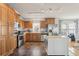 Spacious kitchen featuring stainless steel appliances, wooden cabinets, a kitchen island, and tile floors at 8448 Fantasia Park Way, Riverview, FL 33578