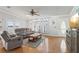 Bright living room featuring hardwood floors, large windows, a ceiling fan, and neutral-toned furniture at 8448 Fantasia Park Way, Riverview, FL 33578