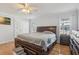 A primary bedroom features hardwood floors, a ceiling fan, and a large dark wood bedroom set at 8448 Fantasia Park Way, Riverview, FL 33578