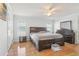 A primary bedroom features hardwood floors, a ceiling fan, and a large dark wood bedroom set at 8448 Fantasia Park Way, Riverview, FL 33578