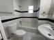 This is a clean and functional bathroom with white tile, black accent stripes, and a shower-tub combo at 101 W Fern St, Tampa, FL 33604