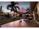 Backyard patio area at sunset with outdoor seating under a shade sail and lush surroundings at 10100 Paradise Blvd, Treasure Island, FL 33706