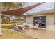 Backyard patio area with seating under a shade sail and a view of the manicured lawn at 10100 Paradise Blvd, Treasure Island, FL 33706