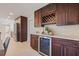 Stylish bar area with rich wood cabinetry, wine storage, and a beverage cooler at 10100 Paradise Blvd, Treasure Island, FL 33706