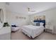 Well-lit bedroom with stylish furniture, a ceiling fan, and bright windows at 10100 Paradise Blvd, Treasure Island, FL 33706