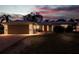 Dusk view of a cozy home with front yard seating and an attached garage, under a colorful evening sky at 10100 Paradise Blvd, Treasure Island, FL 33706