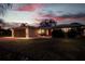 Exterior view of a cozy home at twilight, featuring a well-manicured lawn and inviting front porch seating at 10100 Paradise Blvd, Treasure Island, FL 33706