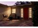 Cozy front porch featuring a red door, seating area, and brick pavers at 10100 Paradise Blvd, Treasure Island, FL 33706