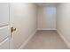 Small hallway featuring tile flooring, white walls, and a modern brass door handle, with a minimalistic and clean design at 10100 Paradise Blvd, Treasure Island, FL 33706