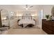 Spacious main bedroom with ceiling fan and tiled floors, offering comfortable seating and a view of a decorative mirror at 10100 Paradise Blvd, Treasure Island, FL 33706