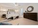 Main bedroom with a ceiling fan, neutral decor, and tiled floors, featuring a decorative mirror and a large dresser at 10100 Paradise Blvd, Treasure Island, FL 33706