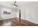 Clean bedroom features neutral walls, wood-look floors, a ceiling fan, and an ensuite bathroom at 1035 County Road 90, Palm Harbor, FL 34684