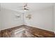 Bright bedroom featuring hardwood floors, a ceiling fan, and two sunlit windows at 1035 County Road 90, Palm Harbor, FL 34684