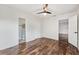 Bright bedroom with wood-look floors, ceiling fan, ensuite bathroom, and walk-in closet at 1035 County Road 90, Palm Harbor, FL 34684