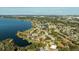 Aerial view of the waterfront home with a lush landscape, private dock, and scenic lake views at 10562 99Th St, Largo, FL 33773