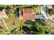 Aerial view of the home showcasing the pool, screened lanai, and private dock leading to the water at 10562 99Th St, Largo, FL 33773