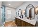 Stylish bathroom with double sink vanity, marble countertops, wood cabinets, and a walk-in shower at 10562 99Th St, Largo, FL 33773