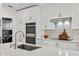 Close up of a well-equipped kitchen with white cabinets and stainless steel appliances and patterned backsplash at 10562 99Th St, Largo, FL 33773