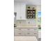 Stylish kitchen detail with gray backsplash and cabinets and an eye-catching decorative storage shelf at 10562 99Th St, Largo, FL 33773