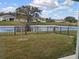 Breathtaking view of the pond and lush green backyard enhanced by black wrought iron fence at 10646 Pepper Dawn Cir, San Antonio, FL 33576