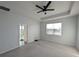 Bright bedroom featuring a ceiling fan, plush carpet, and access to a private balcony at 10646 Pepper Dawn Cir, San Antonio, FL 33576