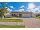 Attractive home exterior with well-manicured landscaping and a paver driveway at 10829 65Th N Way, Pinellas Park, FL 33782