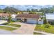 Inviting front exterior featuring a manicured lawn, brick driveway, and attached garage, creating a welcoming curb appeal at 10829 65Th N Way, Pinellas Park, FL 33782