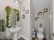 Stylish powder room with pedestal sink, decorative mirror, and charming wall art at 11333 June Briar Loop, San Antonio, FL 33576