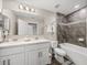 Bathroom with a dual sink vanity, a tiled shower-tub, and modern fixtures at 11333 June Briar Loop, San Antonio, FL 33576