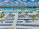 Lagoon community beach with rows of lounge chairs and umbrellas, and clear turquoise water at 11333 June Briar Loop, San Antonio, FL 33576