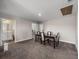 Carpeted dining room featuring a four-chair dark wood dining table set and a white accent chair at 11333 June Briar Loop, San Antonio, FL 33576