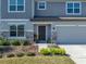 Close up of the entry to a stylish home with fresh landscaping, stone detail and a three car garage at 11333 June Briar Loop, San Antonio, FL 33576