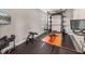 Fully equipped home gym with weight rack, bench, and wall-mounted television at 11333 June Briar Loop, San Antonio, FL 33576