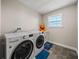 Laundry room with a new washer and dryer, a utility sink, and a bright window at 11333 June Briar Loop, San Antonio, FL 33576