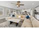 Bright and airy living room featuring a sectional sofa, stylish lighting, and an open floor plan leading to the kitchen at 11333 June Briar Loop, San Antonio, FL 33576