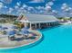 Poolside bar with ample seating next to a community lagoon, with patio seating and umbrellas at 11333 June Briar Loop, San Antonio, FL 33576