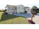 Charming home featuring light yellow siding, blue shutters, and a brick foundation with an inviting front yard at 114 W Saint Johns Way, Apollo Beach, FL 33572