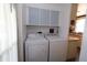 Convenient laundry area equipped with modern washer and dryer units and cabinets at 114 W Saint Johns Way, Apollo Beach, FL 33572