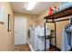 Efficient laundry room with a modern washer and dryer, storage shelves, and access to the backyard at 12478 93Rd Way, Largo, FL 33773