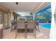 Covered patio with dining set and view of the screened-in pool, ideal for outdoor entertaining and relaxation at 12478 93Rd Way, Largo, FL 33773