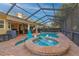 Pool with a spa and connecting seating area, surrounded by a brick patio and screened enclosure at 12478 93Rd Way, Largo, FL 33773