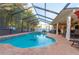 Backyard pool with a jacuzzi, brick patio, outdoor kitchen, and tropical landscaping at 12478 93Rd Way, Largo, FL 33773