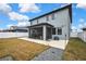 The backyard features a concrete patio perfect for entertaining, surrounded by a white fence and brown grass at 12704 Vander Way, New Port Richey, FL 34654