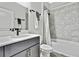 Modern bathroom features a shower-tub combo with gray tile and a vanity with sleek fixtures at 12704 Vander Way, New Port Richey, FL 34654